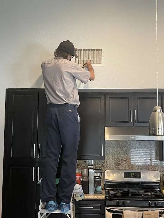 Technician inspecting an air vent during HVAC service in Berkeley Heights